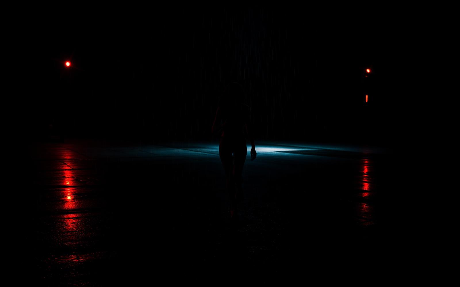 Silhouette einer Frau im nächtlichen Regen